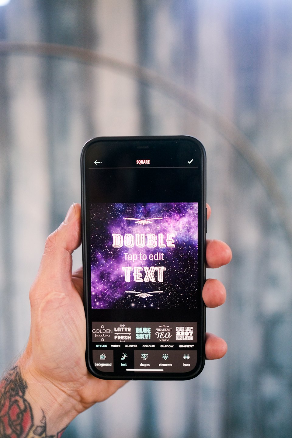 Hand holding a smartphone displaying a text editing application.