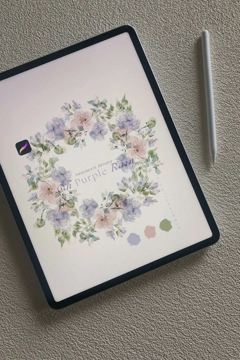 A digital tablet displaying a floral wreath illustration with a stylus.